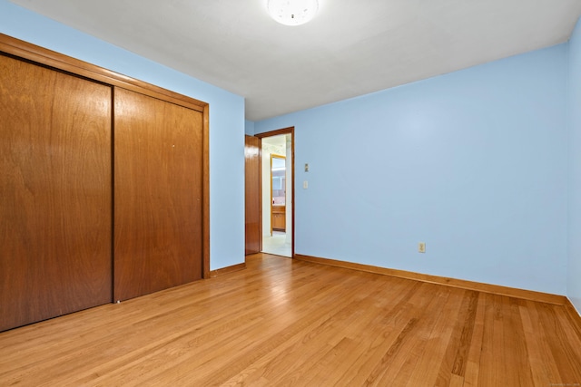 654 Beach Pond Rd, Voluntown, CT 06384 - unfurnished bedroom featuring light wood-style floors, a closet, and baseboards