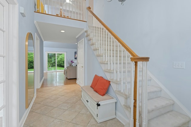 44 Village Ct Unit 44, Wilton, CT 06897 - stairway with a towering ceiling, tile patterned flooring, arched walkways, baseboards, and crown molding