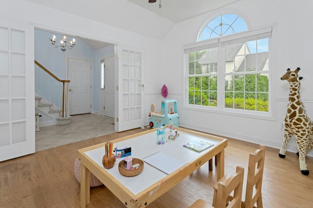44 Village Ct Unit 44, Wilton, CT 06897 - living area featuring lofted ceiling, plenty of natural light, stairway, a chandelier, and wood finished floors