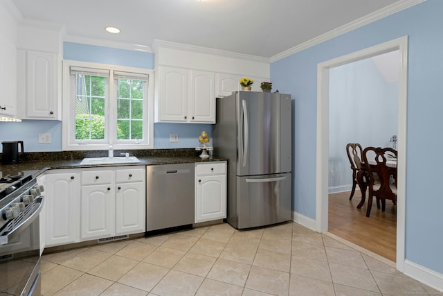 44 Village Ct Unit 44, Wilton, CT 06897 - kitchen featuring stainless steel appliances, a sink, white cabinets, ornamental molding, and light tile patterned flooring