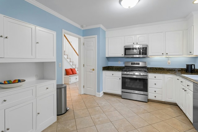 44 Village Ct Unit 44, Wilton, CT 06897 - kitchen featuring appliances with stainless steel finishes, crown molding, white cabinets, light tile patterned flooring, and a sink