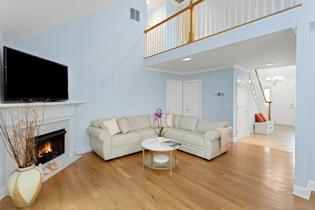44 Village Ct Unit 44, Wilton, CT 06897 - living area featuring a chandelier, baseboards, wood finished floors, a fireplace, and a high ceiling