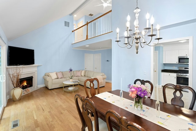 44 Village Ct Unit 44, Wilton, CT 06897 - dining room featuring light wood finished floors, a premium fireplace, high vaulted ceiling, a chandelier, and baseboards