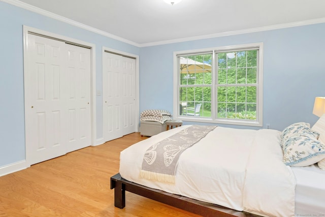 44 Village Ct Unit 44, Wilton, CT 06897 - bedroom featuring two closets, wood finished floors, crown molding, and baseboards