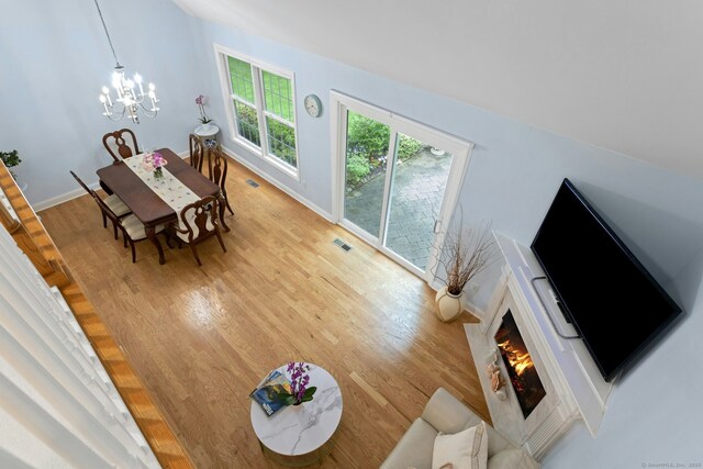 44 Village Ct Unit 44, Wilton, CT 06897 - living room featuring a chandelier, light wood-type flooring, a fireplace, and baseboards