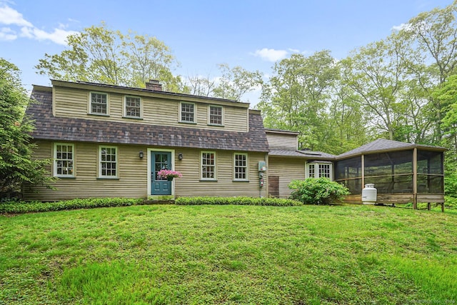 9 Pheasant Ln, Brooklyn, CT 06234 - view of front of home featuring a sunroom, a chimney, a front yard, and roof with shingles