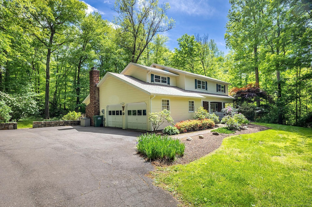 9 Meadowbrook Rd, New Fairfield, CT 06812 - traditional home featuring an attached garage, asphalt driveway, a chimney, and a front yard