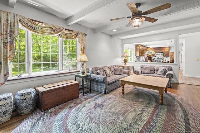9 Meadowbrook Rd, New Fairfield, CT 06812 - living room featuring healthy amount of natural light, wood finished floors, beamed ceiling, ceiling fan, and a textured ceiling