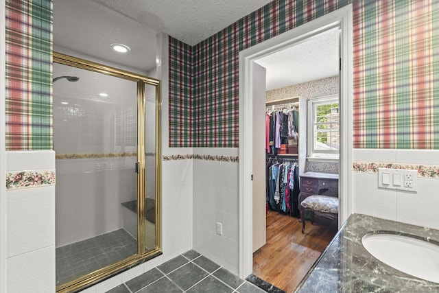 9 Meadowbrook Rd, New Fairfield, CT 06812 - bathroom featuring wallpapered walls, a shower stall, a textured ceiling, a spacious closet, and vanity