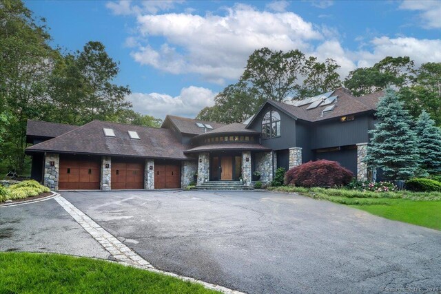 93 Graenest Ridge Rd, Wilton, CT 06897 - view of front facade featuring stone siding, asphalt driveway, and a garage