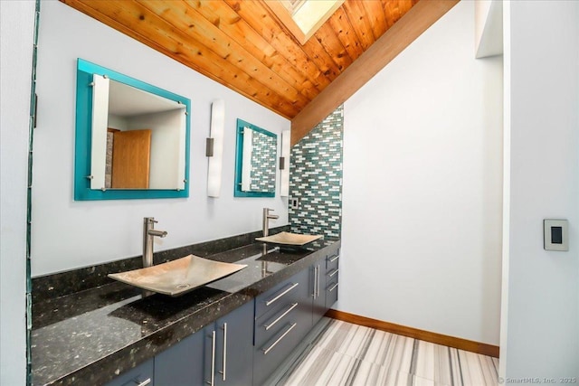 93 Graenest Ridge Rd, Wilton, CT 06897 - bathroom featuring double vanity, a skylight, wood ceiling, baseboards, and vaulted ceiling