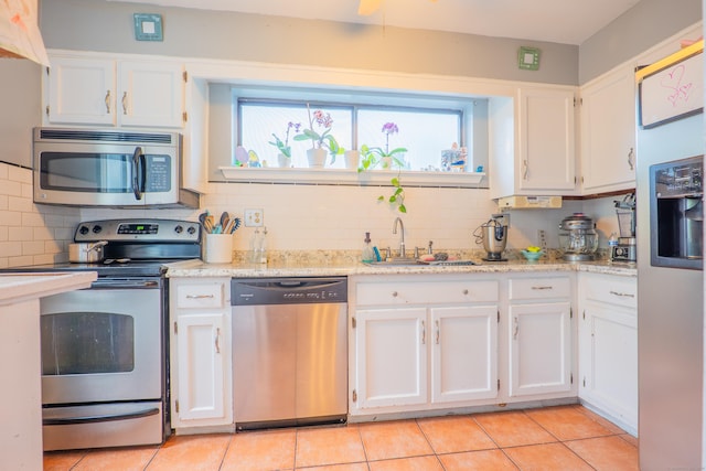 95 Park Ave Apt 14, Danbury, CT 06810 - kitchen featuring stainless steel appliances, a sink, white cabinetry, backsplash, and light tile patterned floors
