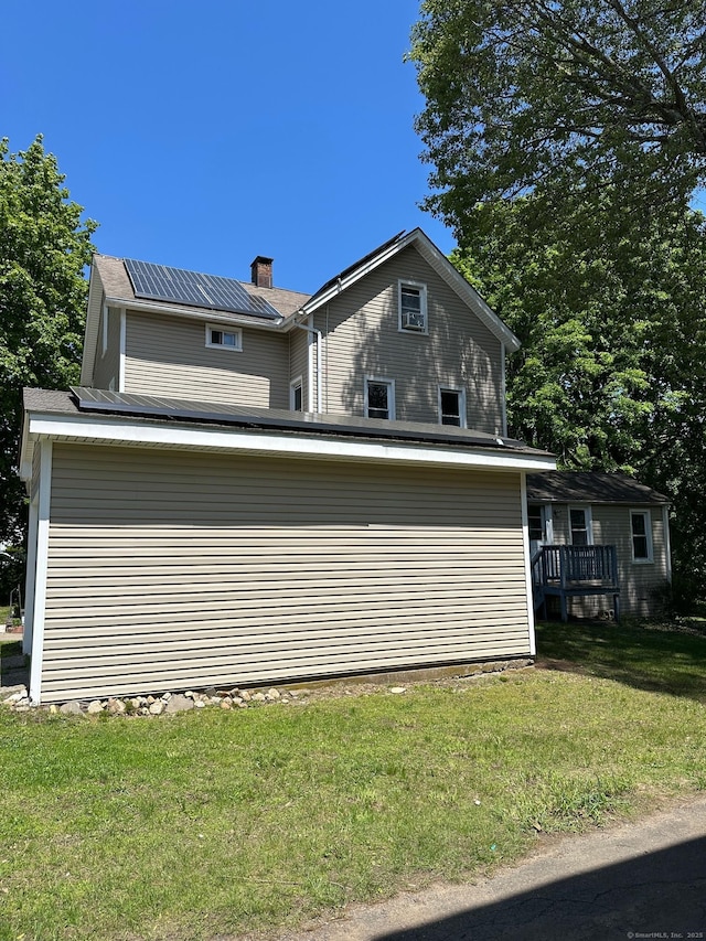 59 Rowan St, Danbury, CT 06810 - view of side of property featuring a lawn, solar panels, and a chimney