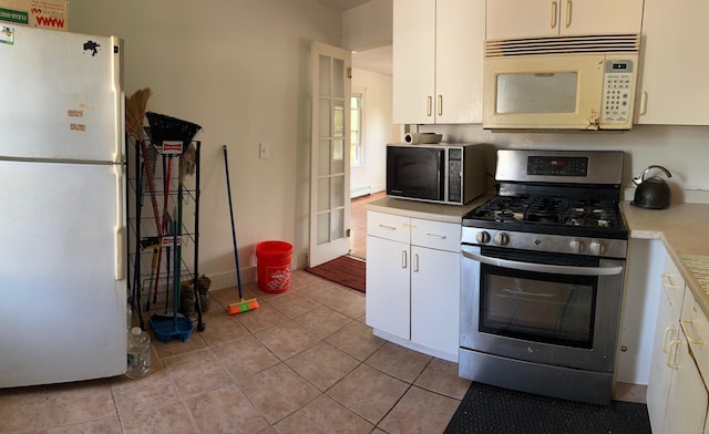 59 Rowan St, Danbury, CT 06810 - kitchen featuring white appliances, light countertops, light tile patterned flooring, and white cabinets