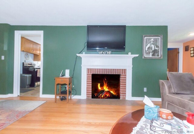 45 S Eagle St, Plymouth, CT 06786 - living room with wood finished floors, a brick fireplace, and baseboards