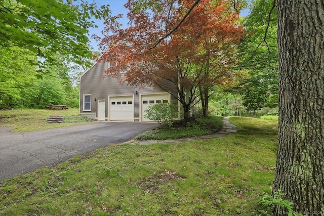 1155 Arbutus St, Middletown, CT 06457 - view of side of property with asphalt driveway, an attached garage, and a yard