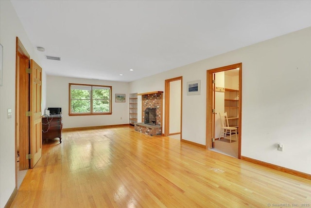 1155 Arbutus St, Middletown, CT 06457 - unfurnished living room with light wood-type flooring, baseboards, and a brick fireplace