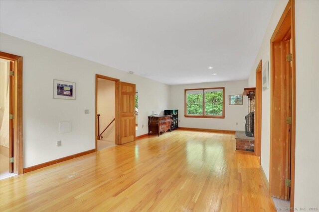 1155 Arbutus St, Middletown, CT 06457 - unfurnished living room with light wood finished floors, baseboards, recessed lighting, and a brick fireplace