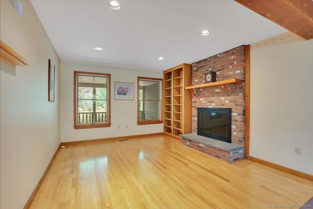 1155 Arbutus St, Middletown, CT 06457 - unfurnished living room featuring baseboards, wood finished floors, a brick fireplace, recessed lighting, and built in shelves