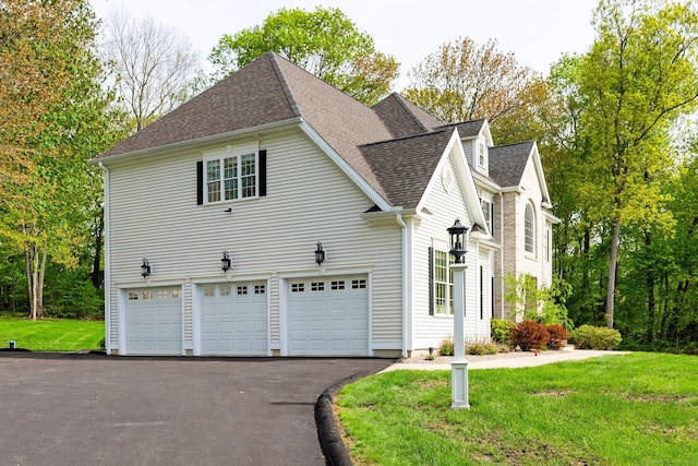 64 Warren Gln, Burlington, CT 06013 - view of side of home featuring asphalt driveway, an attached garage, a shingled roof, and a yard