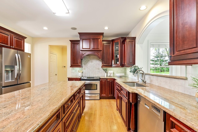 64 Warren Gln, Burlington, CT 06013 - kitchen with appliances with stainless steel finishes, dark brown cabinets, a sink, light stone countertops, and light wood-type flooring