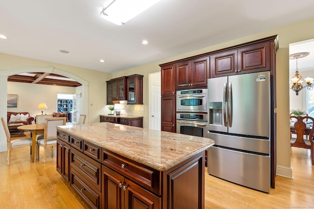 64 Warren Gln, Burlington, CT 06013 - kitchen with stainless steel appliances, arched walkways, light wood-style flooring, a kitchen island, and recessed lighting