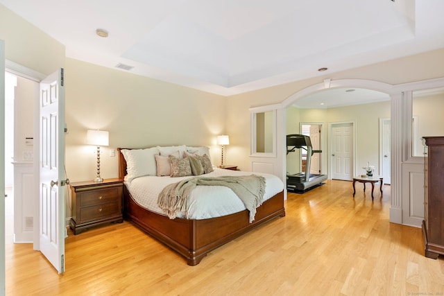 64 Warren Gln, Burlington, CT 06013 - bedroom featuring arched walkways, light wood finished floors, and a tray ceiling
