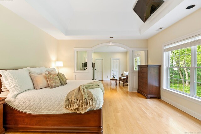64 Warren Gln, Burlington, CT 06013 - bedroom with arched walkways, a raised ceiling, light wood-type flooring, and baseboards