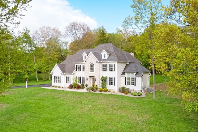 64 Warren Gln, Burlington, CT 06013 - colonial house featuring a front lawn, central AC, and view of scattered trees