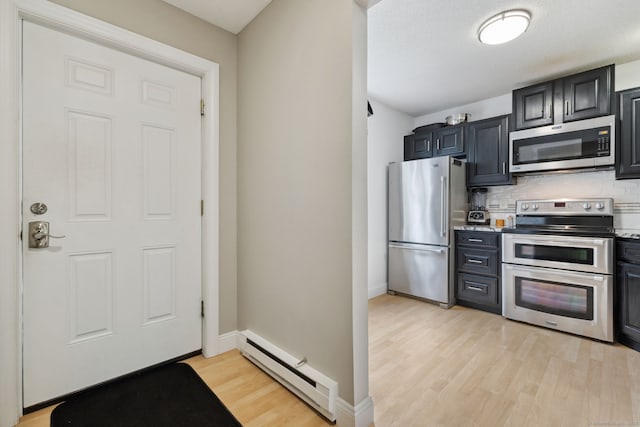 745 Merrow Rd Apt 113, Coventry, CT 06238 - kitchen with appliances with stainless steel finishes, a baseboard heating unit, light wood-style floors, tasteful backsplash, and baseboards