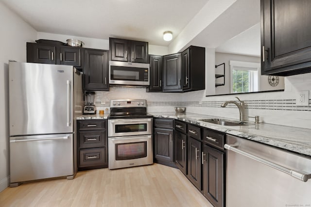745 Merrow Rd Apt 113, Coventry, CT 06238 - kitchen with appliances with stainless steel finishes, a sink, light wood-style floors, and backsplash