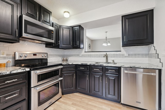 745 Merrow Rd Apt 113, Coventry, CT 06238 - kitchen with appliances with stainless steel finishes, a sink, a chandelier, and dark cabinetry