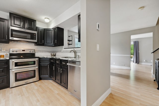 745 Merrow Rd Apt 113, Coventry, CT 06238 - kitchen featuring appliances with stainless steel finishes, a sink, backsplash, and dark cabinetry