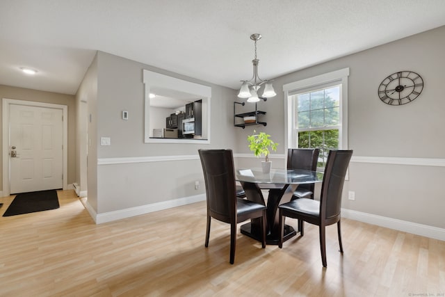 745 Merrow Rd Apt 113, Coventry, CT 06238 - dining area with light wood finished floors, baseboards, and a chandelier