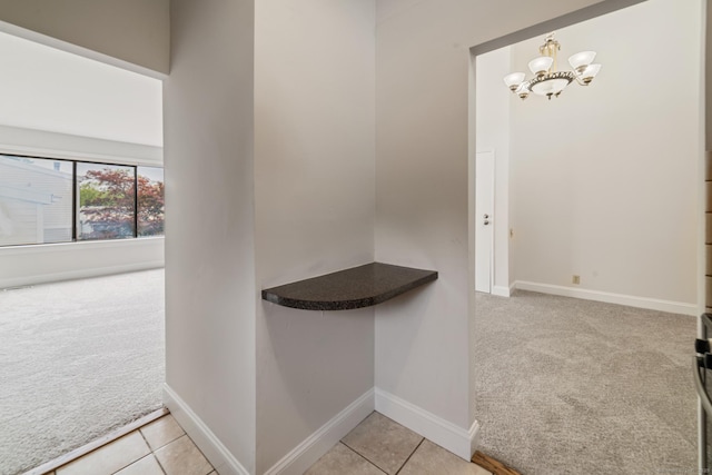 19 Keeler Close Close Unit 19, Ridgefield, CT 06877 - hall featuring light carpet, a chandelier, baseboards, and light tile patterned floors