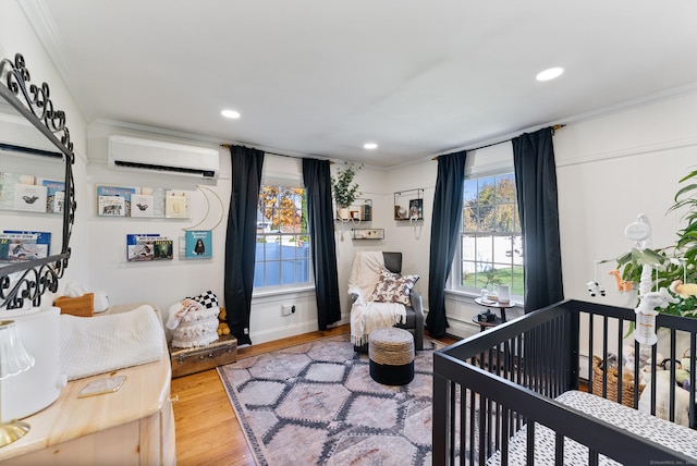 17 Saint Thomas St, Enfield, CT 06082 - bedroom with an AC wall unit, wood finished floors, a crib, recessed lighting, and ornamental molding