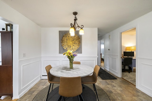 53 Roosevelt Blvd, Enfield, CT 06082 - dining area with stone tile floors, a chandelier, a decorative wall, a baseboard radiator, and wainscoting