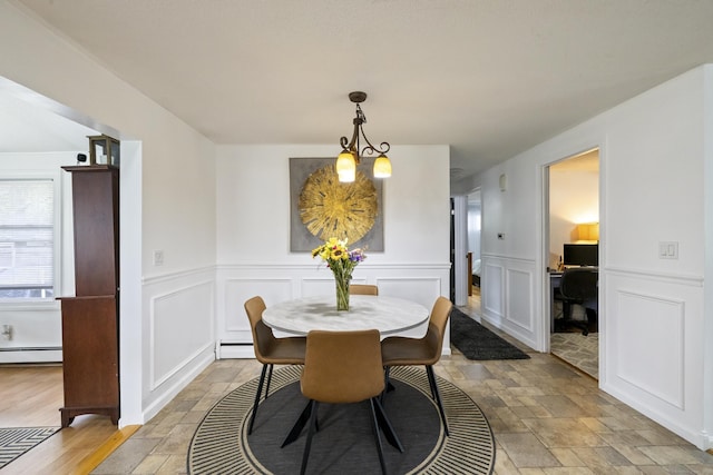 53 Roosevelt Blvd, Enfield, CT 06082 - dining area featuring baseboard heating, stone tile flooring, a baseboard radiator, a decorative wall, and a chandelier