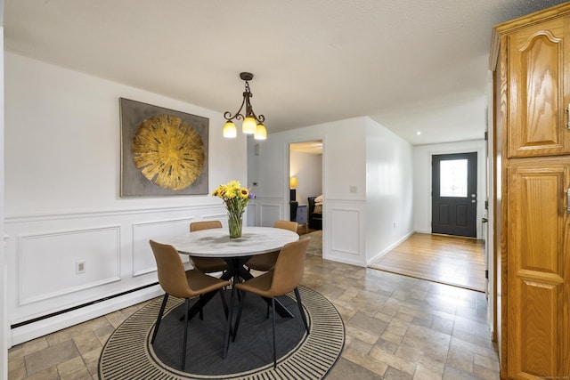 53 Roosevelt Blvd, Enfield, CT 06082 - dining room featuring stone tile flooring, a baseboard radiator, a decorative wall, and a wainscoted wall