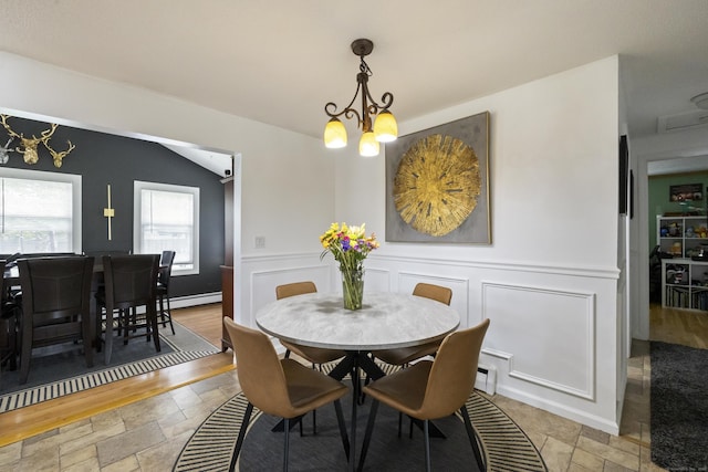 53 Roosevelt Blvd, Enfield, CT 06082 - dining space featuring a chandelier, stone tile floors, a baseboard radiator, wainscoting, and a decorative wall