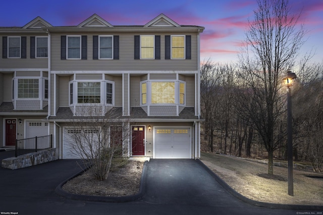 multi unit property with driveway and an attached garage