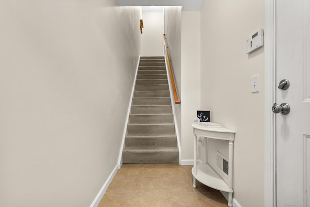 stairs featuring baseboards and tile patterned floors