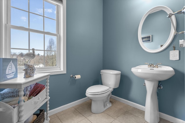 bathroom featuring baseboards, toilet, and tile patterned flooring