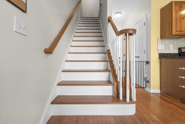 staircase featuring hardwood / wood-style flooring and baseboards