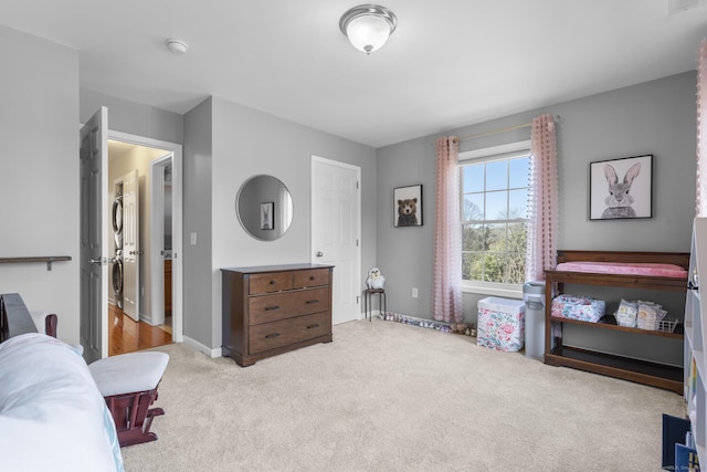 bedroom featuring stacked washing machine and dryer, carpet, and baseboards