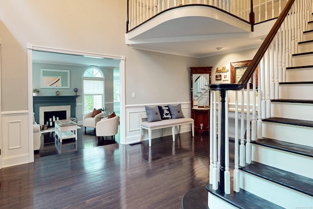 3 Inwood Ln, Woodbury, CT 06798 - stairway featuring a fireplace, a wainscoted wall, a decorative wall, wood finished floors, and crown molding