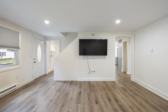 53 Kalish Ave, Enfield, CT 06082 - unfurnished living room featuring a baseboard radiator, wood finished floors, baseboards, and recessed lighting