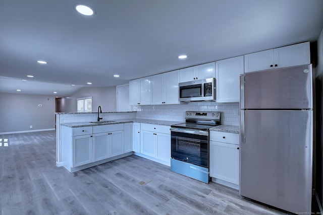 66 Nancy Ln, Naugatuck, CT 06770 - kitchen with appliances with stainless steel finishes, white cabinetry, a sink, light stone countertops, and backsplash