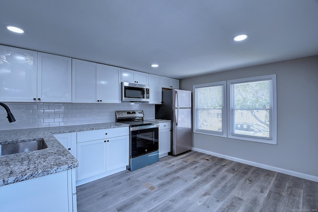 66 Nancy Ln, Naugatuck, CT 06770 - kitchen with stainless steel appliances, a sink, white cabinetry, decorative backsplash, and baseboards