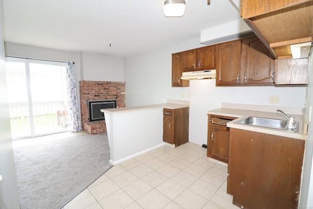 678 Savin Ave Apt 2J, West Haven, CT 06516 - kitchen featuring under cabinet range hood, a sink, light carpet, open floor plan, and a brick fireplace